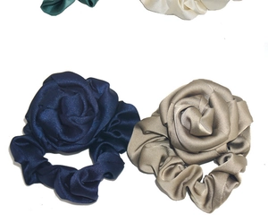 Detailed shot of silk rose scrunchies in navy blue and khaki with satin texture