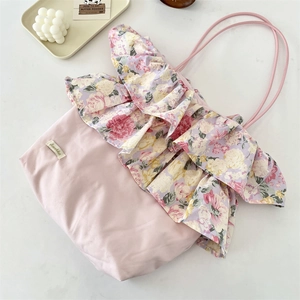 Dettaglio della borsa tote rosa con bordo a volant floreali e motivo a rose retrò