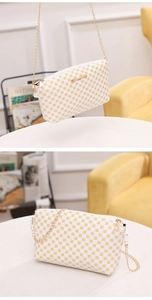 Close-up of white crossbody bag with yellow geometric print and gold chain strap