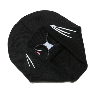 Detail of black knit beanie featuring white cat whiskers and pink embroidered accents