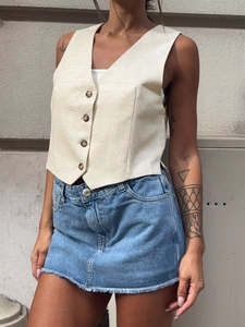 Minimalist beige cotton linen vest paired with blue denim skirt in a casual summer outfit