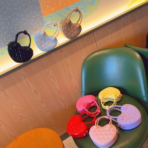 Macro detail of heart-shaped quilted PVC handbags in multiple vibrant candy colors