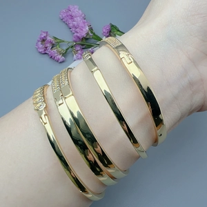 Elegant gold bangle set with sparkling cubic zirconia stones shown on a wrist