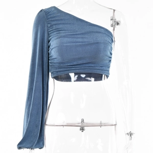 Détail du haut bleu à une épaule et manche longue avec texture de tissu froncé élégant