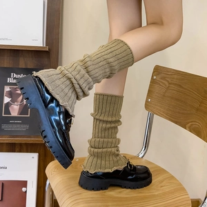 Close-up of olive green ribbed knit leg warmers with retro academic style texture