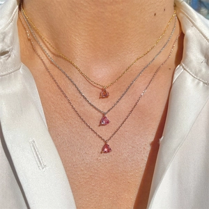 Pink heart pendant necklace set with gold and silver chains worn on a model