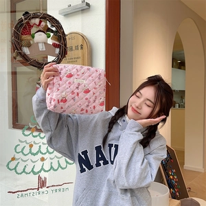 Gros plan d'une trousse à maquillage matelassée rose avec motifs de dessins animés
