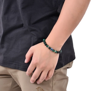 Detail eines 8mm grünen Landkartenstein-Armbands mit Evil-Eye-Charm am Handgelenk