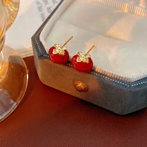 Vintage style red enamel persimmon stud earrings with golden bow detail on suede box