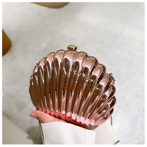 Macro shot of rose gold shell evening clutch with metallic texture and gold clasp