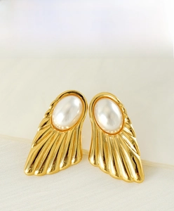 Macro shot of 18K gold plated stainless steel fan earrings with pearls on silk texture