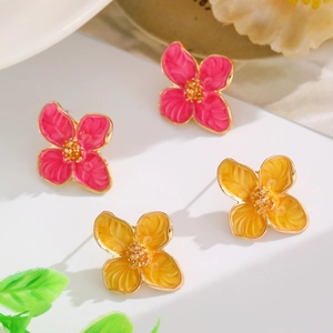 Detail view of pink and yellow four-petal flower earrings with golden texture