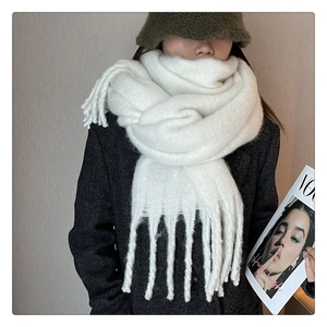 Detailed texture of thick white mohair-style scarf with long decorative tassels