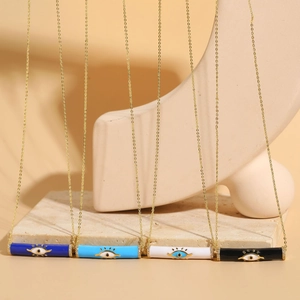 Detailed macro view of four colorful zircon devil eye tube pendants on gold chains