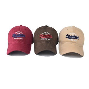Detail of three embroidered cotton baseball caps in burgundy, coffee, and khaki colors