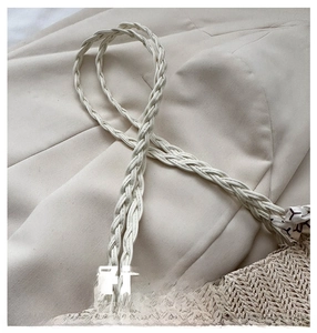 Close-up of comfortable woven handles and natural texture on the beige straw tote bag