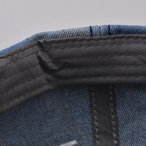 Close-up of high-density stitching and grey sweatband inside the denim baseball cap