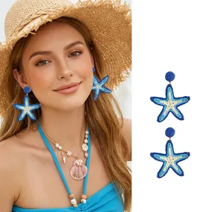 Nahaufnahme von blauen Seestern-Ohrringen mit Webstruktur an einem Modell für den Sommerlook
