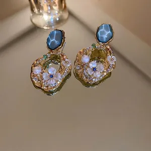 Boucles d'oreilles vintage fleurs avec pierres bleues et perles sur miroir doré