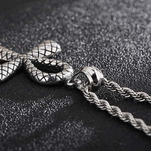 Gros plan sur la texture d'écailles de serpent vintage d'un pendentif croix égyptienne