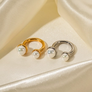 18K gold and silver stainless steel open rings with pearls on silk fabric background