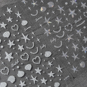 Macro shot of 3D embossed sea shell and starfish nail stickers with holographic pearl finish