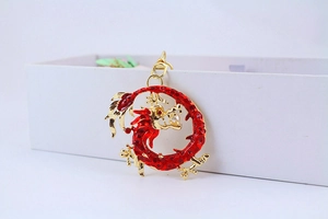 Macro shot of a Chinese dragon keychain with red enamel and a white bead in its mouth