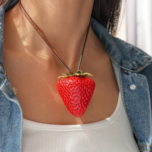 Close-up of a large realistic strawberry pendant necklace with brown leather cord