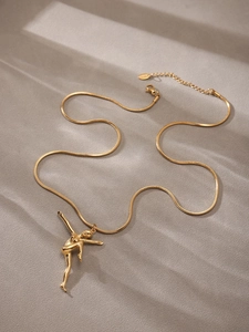 Detail of gold snake chain necklace with dancing ballerina pendant and lobster clasp