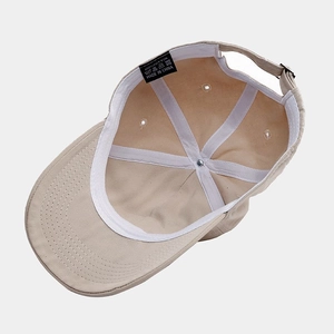 Detail view of khaki cotton baseball cap interior with stitching and adjustable strap