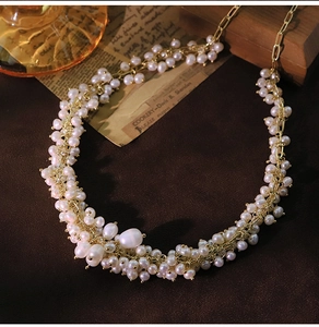 Close-up of vintage rice pearls and baroque pendant necklace with golden chain link detail