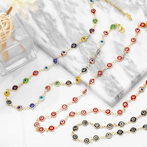 Detailed view of colorful Evil Eye resin bead necklaces on a gold link chain