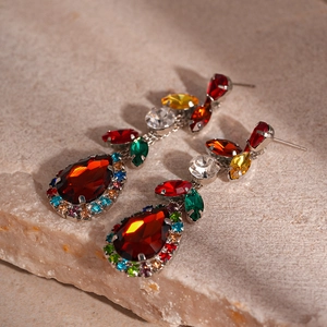 Macro shot of vintage teardrop earrings with red pear-shaped stones and colorful zircon