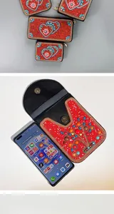 Détail de sac artisanal en perles rouges avec pochette de téléphone cœur brodée