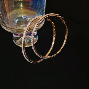 Grandi orecchini a cerchio dorati con pavé di zirconi brillanti per uno stile chic