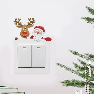 Macro view of watercolor Santa and reindeer stickers on a white wall switch cover