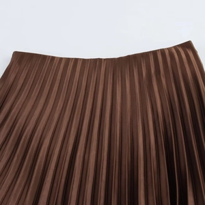 Detailed macro view of the pleated texture on a bronze satin midi skirt fabric