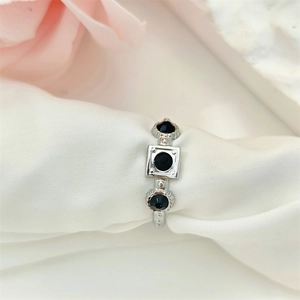 Minimalist silver geometric open ring with black crystals on white silk background