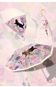Detail of three-fold umbrella featuring floral interior with black cat and gold hook handle