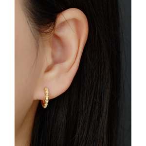Close-up of gold S925 sterling silver hoop earring with paved diamonds on earlobe