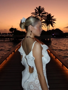 Détail d'une robe blanche en dentelle avec volants et design élégant à dos ouvert