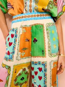 Detail of colorful poker print wide-leg pants with elastic waist and satin texture