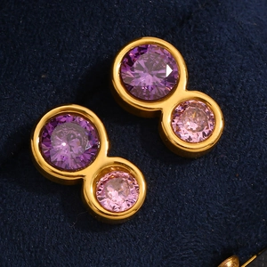 Macro view of gold stainless steel figure-eight earrings with purple and pink gemstones