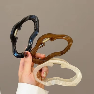 Three hollow jelly cloud hair claws in black, amber, and cream for thick hair styling