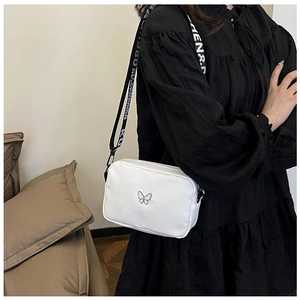 Detail of white nylon crossbody bag with metal butterfly and branded wide strap