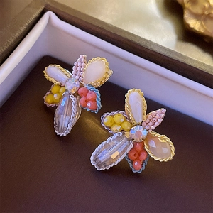 Vue détaillée de boucles d'oreilles fleuries faites main avec perles et centre en cristal