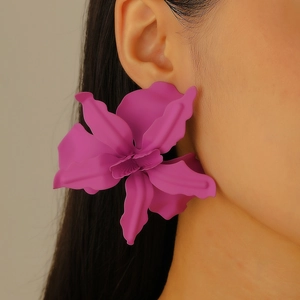 Close-up of oversized purple 3D pleated flower earring worn on ear for party style