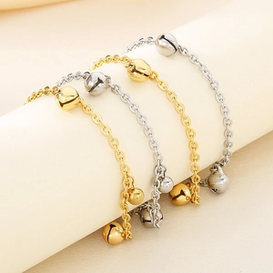 Détails des bracelets de cheville cloches dorées et argentées sur un présentoir moderne