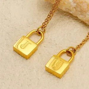 18K gold plated necklace with engraved letter J padlock pendant on a textured stone base