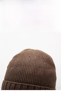 Close-up of brown winter knit beanie showing detailed ribbed texture and soft yarn
